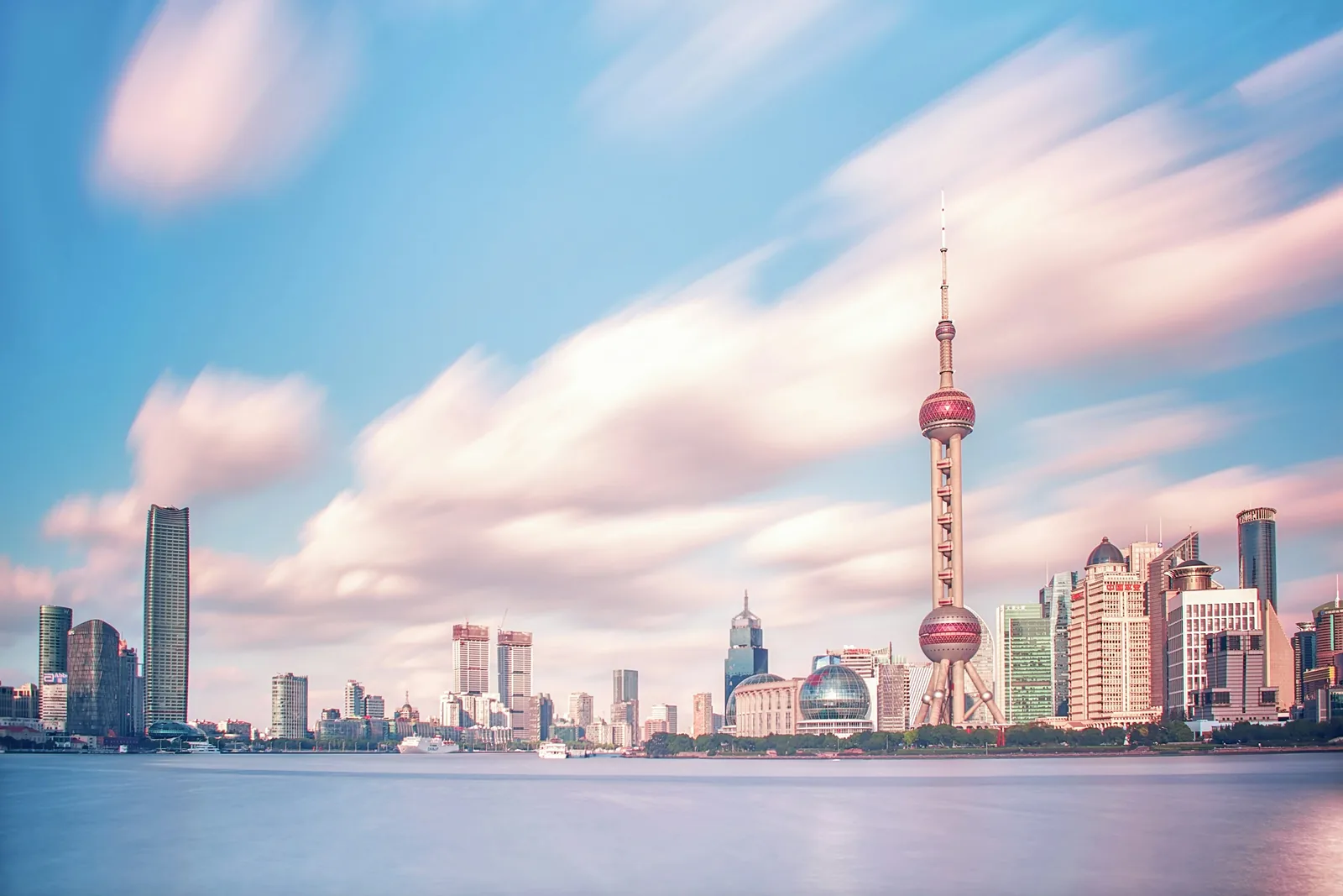 Shanghai skyline across the Huangpu River in soft daylight