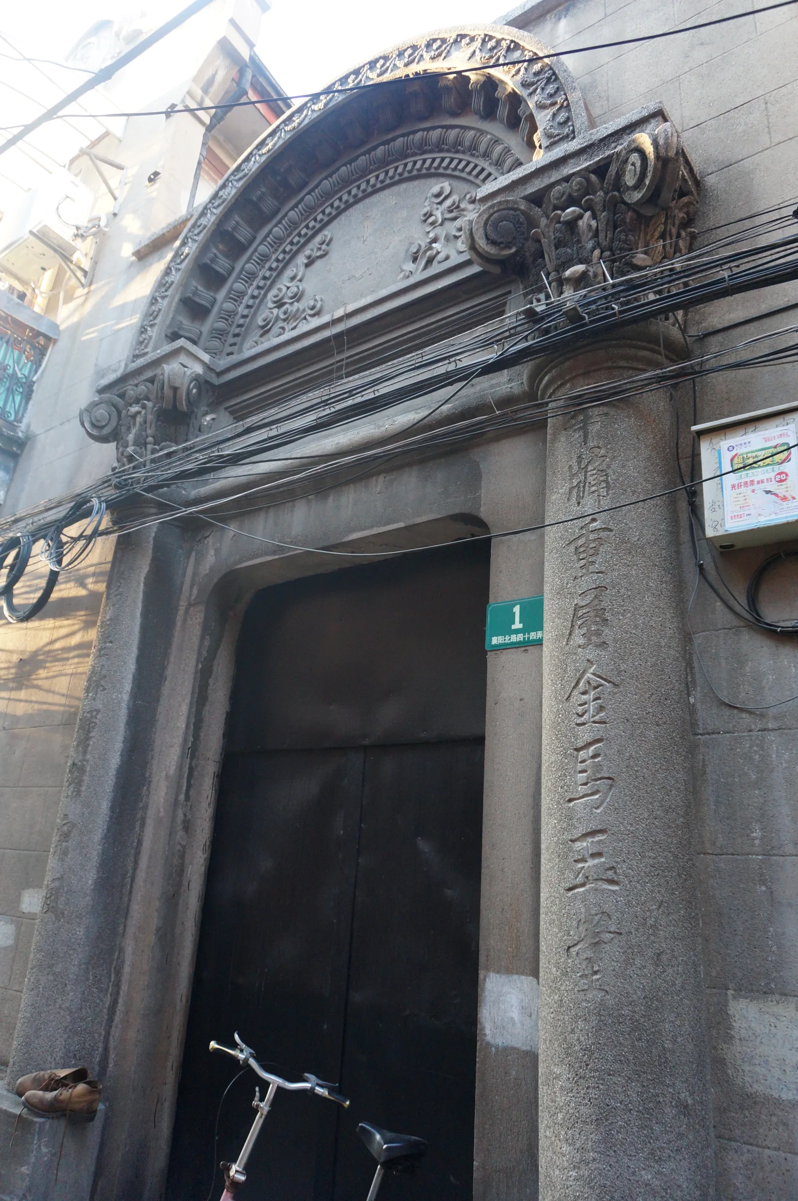 A classic shikumen doorway on North Xiangyang Road, showing the carved stone frame and heavy wooden entrance